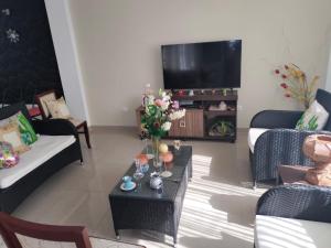 a living room with couches and a table with flowers on it at Apartamento in Arequipa