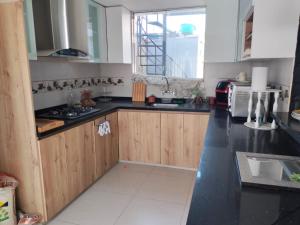 a kitchen with wooden cabinets and a black counter top at Apartamento in Arequipa