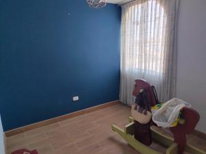 a room with a blue wall and a rocking horse at Apartamento in Arequipa