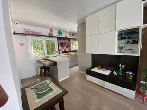 a kitchen with white cabinets and a glass bowl on a table at Hostel Beija-Flor in Itajaí