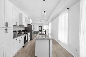 a kitchen with white cabinets and a marble counter top at Full Duplex Retreat-Two Homes Near Eastside- Family Friendly in Indianapolis