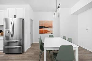 a kitchen with a refrigerator and a table with chairs at Full Duplex Retreat-Two Homes Near Eastside- Family Friendly in Indianapolis