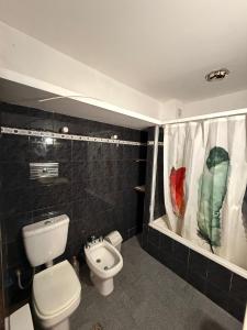 a bathroom with a toilet and a shower curtain at San Jorge in San Clemente del Tuyú