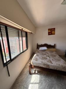 a bedroom with a bed in a room with windows at San Jorge in San Clemente del Tuyú +4 photos