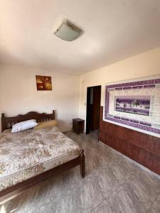 a bedroom with a bed and a painting on the wall at San Jorge in San Clemente del Tuyú