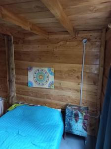 a bedroom in a log cabin with a bed at Cabaña El Poeta in Cuesta Blanca