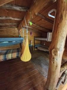 a room with a hammock in a log cabin at Cabaña El Poeta in Cuesta Blanca