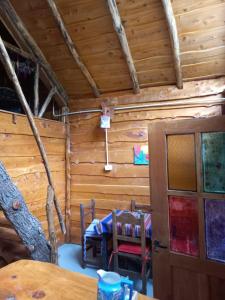 a room with a table and chairs in a cabin at Cabaña El Poeta in Cuesta Blanca