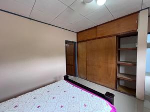 a bedroom with a bed and a wooden cabinet at Apartment near the Río Niño in Upala