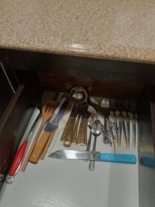 un cajón lleno de muchos utensilios de cocina en Carlo Van Apartment, en Accra