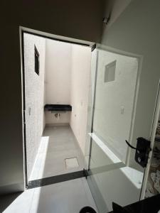 a hallway with a glass door in a room at Espaço completo com garagem, estrutura e móveis novos! in Rondonópolis