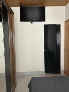 a bedroom with a flat screen tv on the wall at Espaço completo com garagem, estrutura e móveis novos! in Rondonópolis