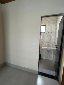 a bathroom with a glass shower and a marble wall at Espaço completo com garagem, estrutura e móveis novos! in Rondonópolis +7 photos