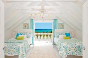 two beds in a room with a view of the ocean at Bahama Mama home in Governorʼs Harbour +28 photos
