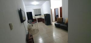 a living room with a tv and a couch and a table at Macas Comfort Apartment in Macas