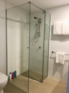 a glass shower stall in a bathroom with a toilet at Minimalist Studio Escape 31506-2 in Brisbane