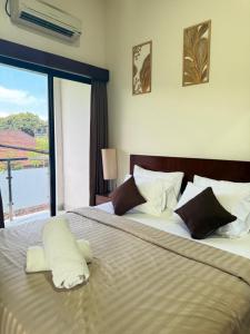 a bedroom with a large bed with a large window at Mesari Living Bali in Denpasar
