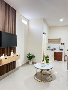 a living room with a table and a kitchen at Mesari Living Bali in Denpasar