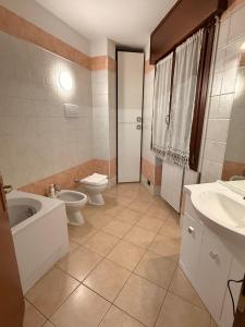 a bathroom with a toilet and a tub and a sink at Acqueria Residence in Vigonza