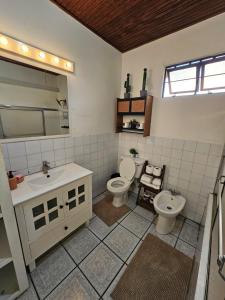 a bathroom with two toilets and a sink at The Carnival Residence at Queens Park Savannah in Port-of-Spain