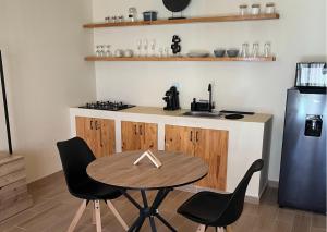 a kitchen with a table and two chairs and a refrigerator at Villa con piscina privada, estilo mediterraneo in Tubará