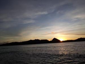 a sunset over a large body of water at Seaview Apartments in Korotogo