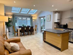 a kitchen and living room with a couch and a table at Squires House Long Stays Sleep 10 Free Parking 