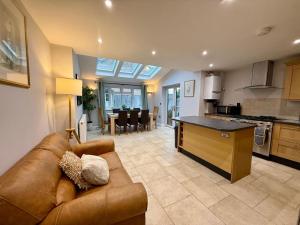 a living room with a brown couch and a kitchen at Squires House Long Stays Sleep 10 Free Parking 
