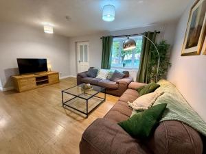 a living room with a couch and a tv at Squires House Long Stays Sleep 10 Free Parking 