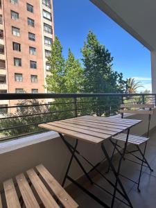 a wooden table and bench on a balcony with a view at Keep walking in Nuñoa in Santiago
