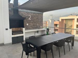 a black table and chairs on a balcony with a stove at Keep walking in Nuñoa in Santiago