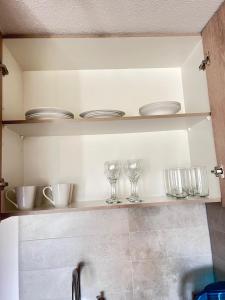 a kitchen shelf with glasses and dishes on it at Keep walking in Nuñoa in Santiago