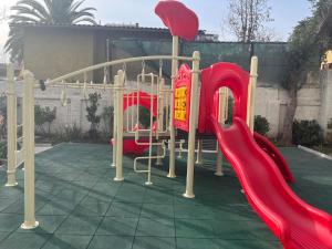 a playground with a red slide and a red slide at Keep walking in Nuñoa in Santiago