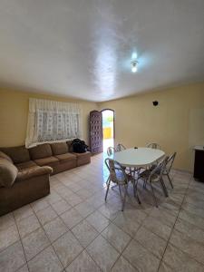 a living room with a table and chairs and a couch at Casa em Shangri-la próxima ao mar in Pontal do Paraná