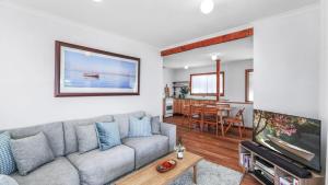 a living room with a couch and a tv at King Stingray in Currarong +20 photos