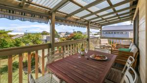 a wooden table on a balcony with a view of the ocean at King Stingray in Currarong