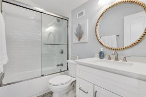 a bathroom with a toilet and a sink and a mirror at Drift Away at The Ocean Gallery in Saint Augustine +13 photos
