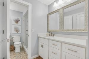 a white bathroom with a sink and a toilet at Drift Away at The Ocean Gallery in Saint Augustine