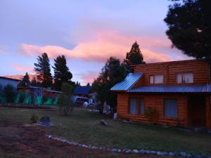ein kleines Holzhaus in einem Hof bei Sonnenuntergang in der Unterkunft Cabaña La Delfina in Epuyén