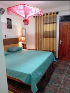 a bedroom with a large bed with a pink umbrella at Princess Villa Kandy Rail Station in Kandy
