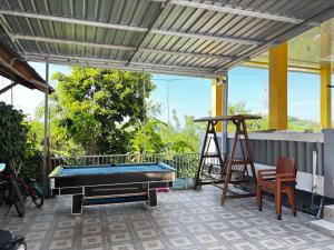 a pool table under awning on a patio at Tarsan Homestay in Labuan Bajo