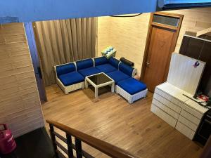 a living room with a blue couch and a table at Pasteur House in Bandung