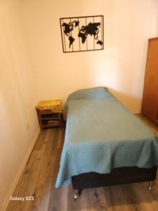 een slaapkamer met een bed met een blauwe deken bij El patio de rosy in Maldonado