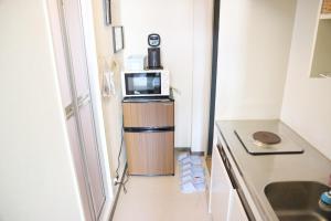 a small kitchen with a microwave and a refrigerator at Joynas Ise / Vacation STAY 31272 in Ise