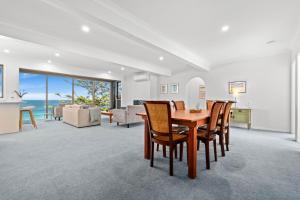 een eetkamer en woonkamer met een tafel en stoelen bij Forresters Dunes - Downstairs in Wamberal