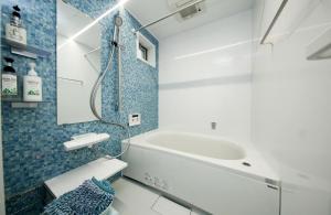 ein Badezimmer mit Waschbecken und Badewanne in der Unterkunft Higashi Rokugou WHITE / Vacation STAY 4276 in Tokio