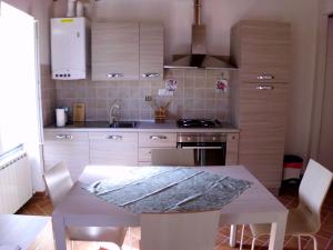 a kitchen with a table with chairs and a counter top at Casa Natale in Corvara