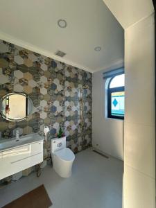 a bathroom with a toilet and a sink and a mirror at The Vista My Hoa in Ninh Hải