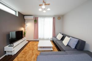 ein Wohnzimmer mit Sofa und Fernseher in der Unterkunft HigashirokugoBLACK / Vacation STAY 4280 in Tokio