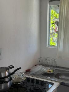 a kitchen with a stove and a sink and a window at Pousada Dona Zilma Refugio Paradisíaco 2 in Penha